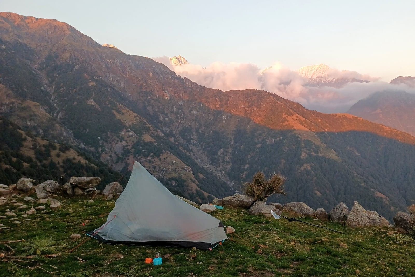 A lightweight tent pitched on a mountain ridge at sunrise above cloud-filled valleys