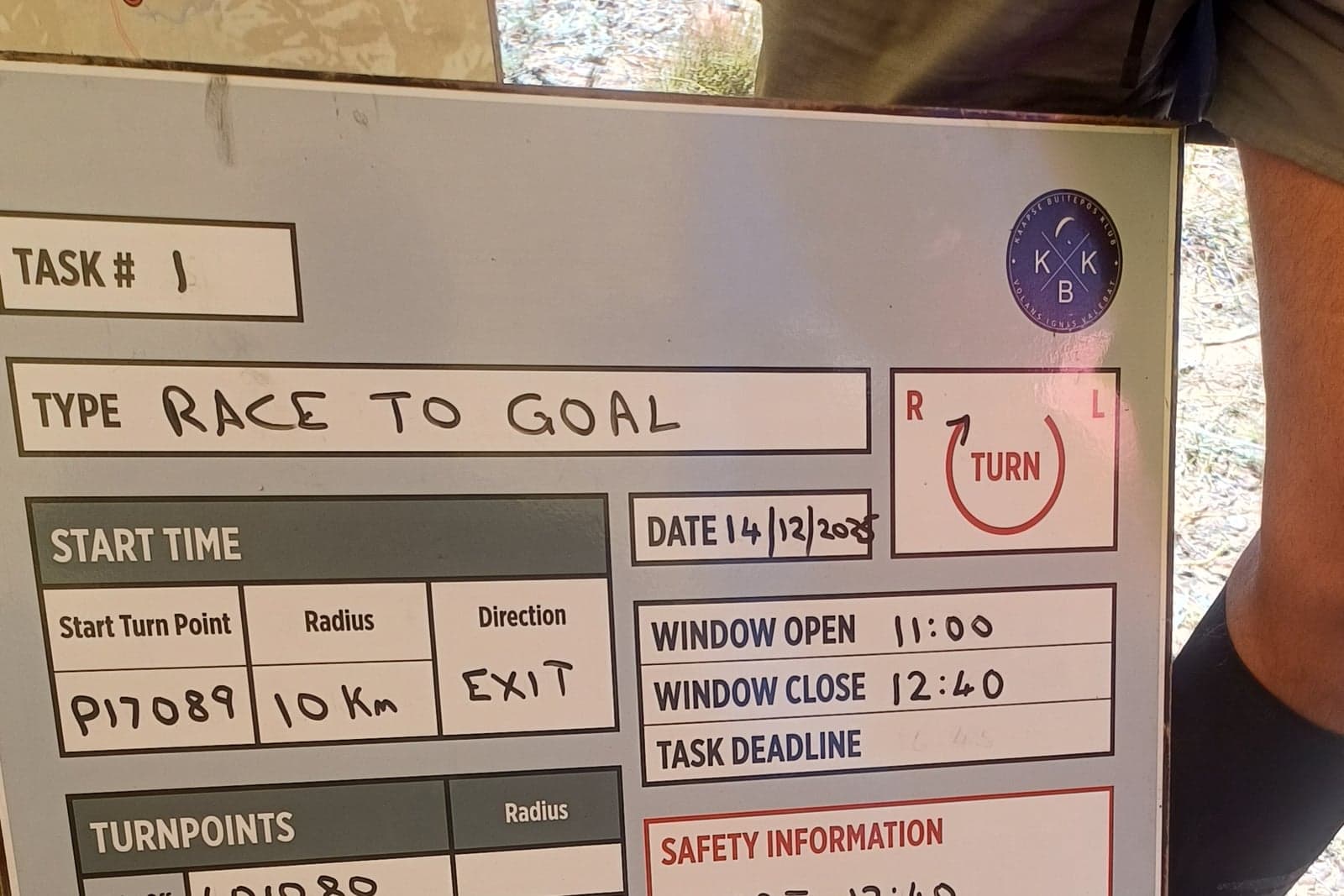 A handwritten competition task board showing turnpoints, start window and safety information